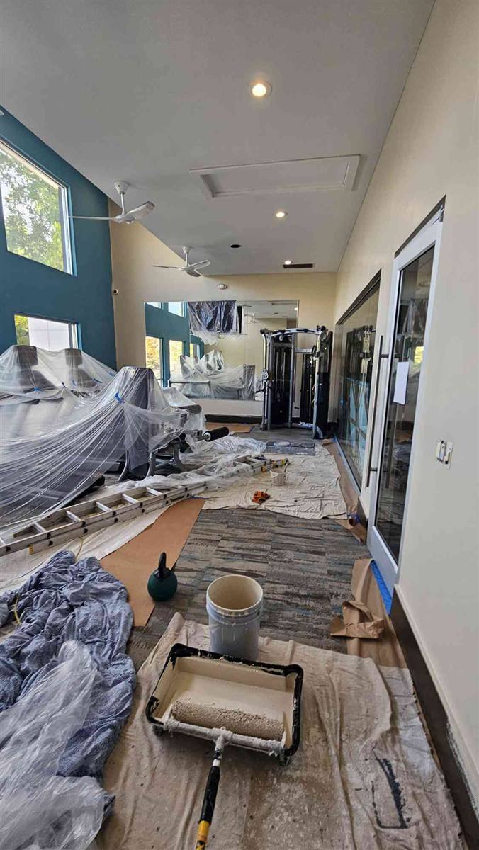 Fitness center after: warm neutral walls, equipment protected and uncovered