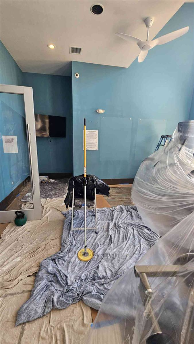 Fitness center before: dated teal walls with equipment wrapped for painting