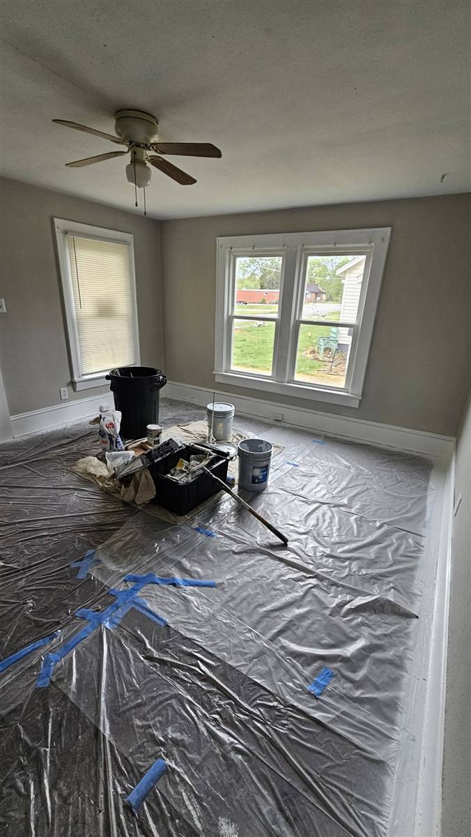Bedroom walls freshly repainted in a modern gray with white trim