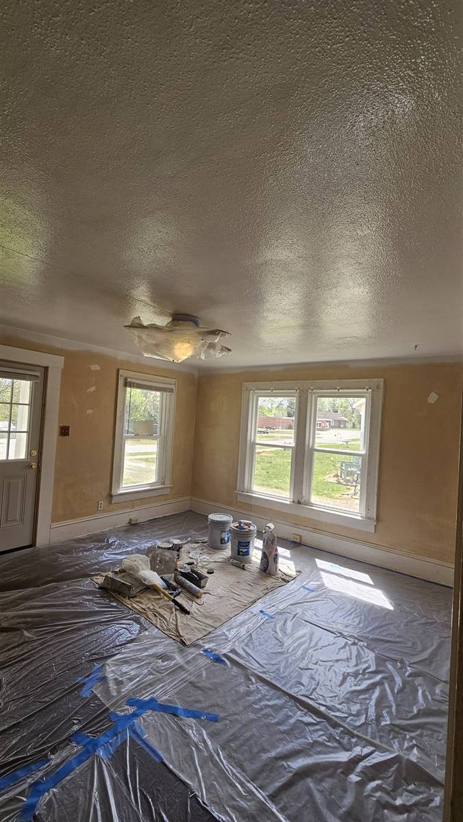 Bedroom before: patched tan walls awaiting paint